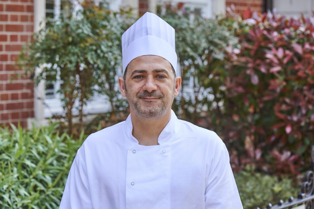 Mauro Ferri smiling in his chef whites outside